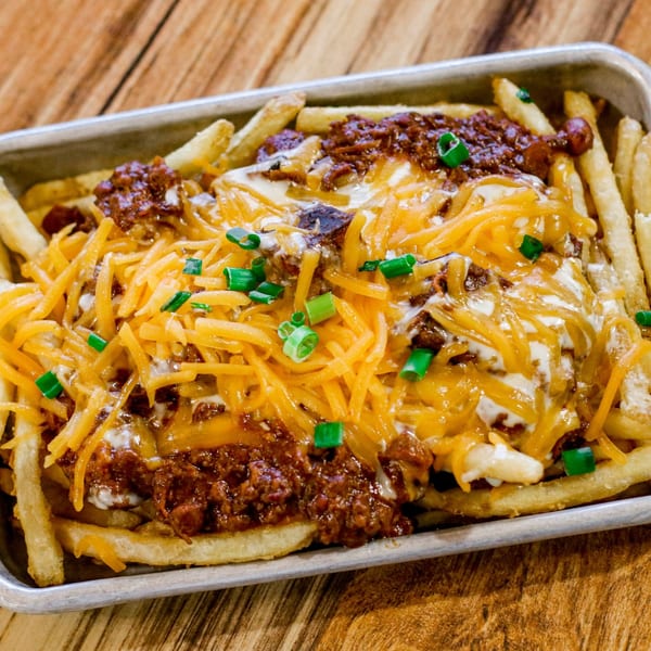 Gettin' Basted's chili cheese fries, topped with shredded cheddar, sour cream, and green onions.