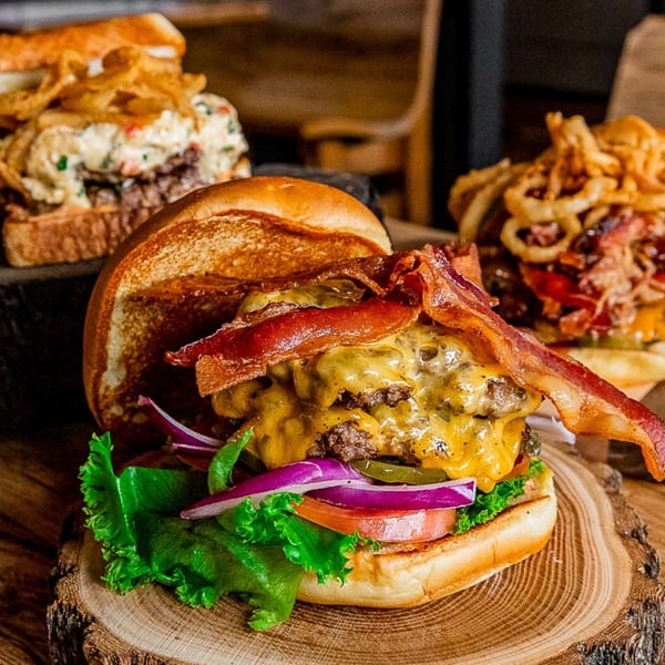 A Gettin' Basted double cheeseburger with bacon, lettuce, tomato, onion, and pickles.