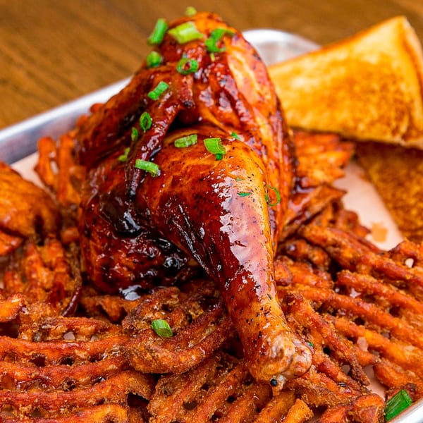 Gettin' Basted BBQ chicken leg and thigh with waffle fries and toast on a metal tray.